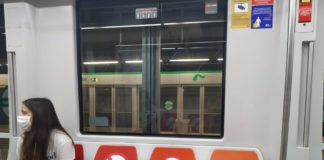 Una joven con mascarilla viaja en el Metro de Sevilla.