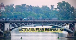 Greenpeace descuelga una pancarta en el puente de Triana para pedir la activación urgente del Plan Respira