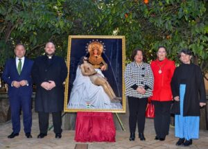 El cartel, que este año representa a Nuestra Señora de la Soledad Coronada y al Santísimo Cristo Yacente en sus brazos, presentándolo al pueblo de Huévar.